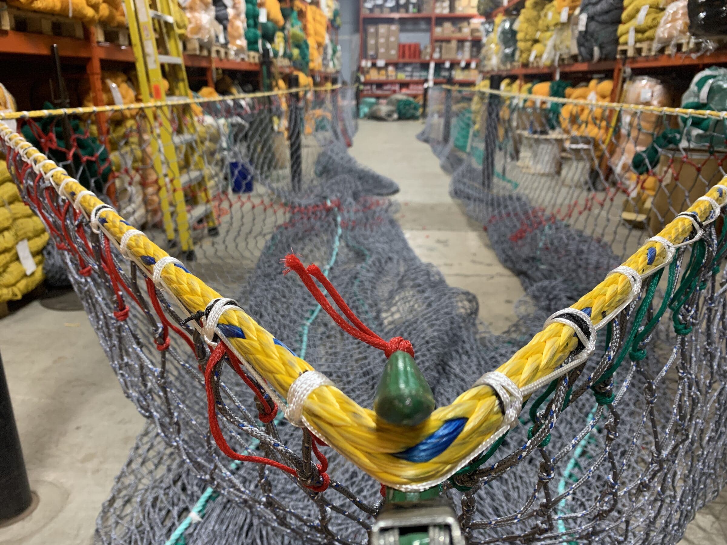 The Dartmouth floor looking down the aisle, a headline rigged in the foreground and racking stacked with netting on both sides