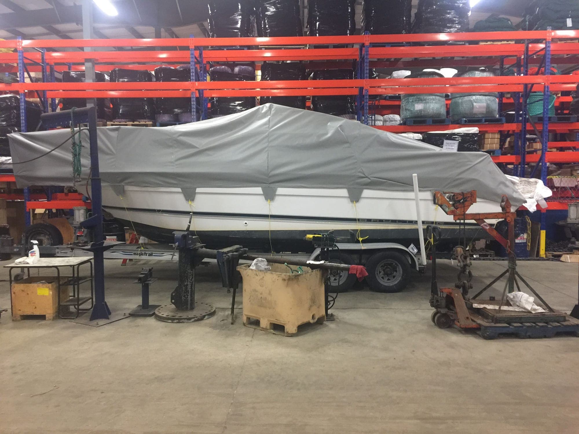 Boats racked under fitted grey covers in the storage shed