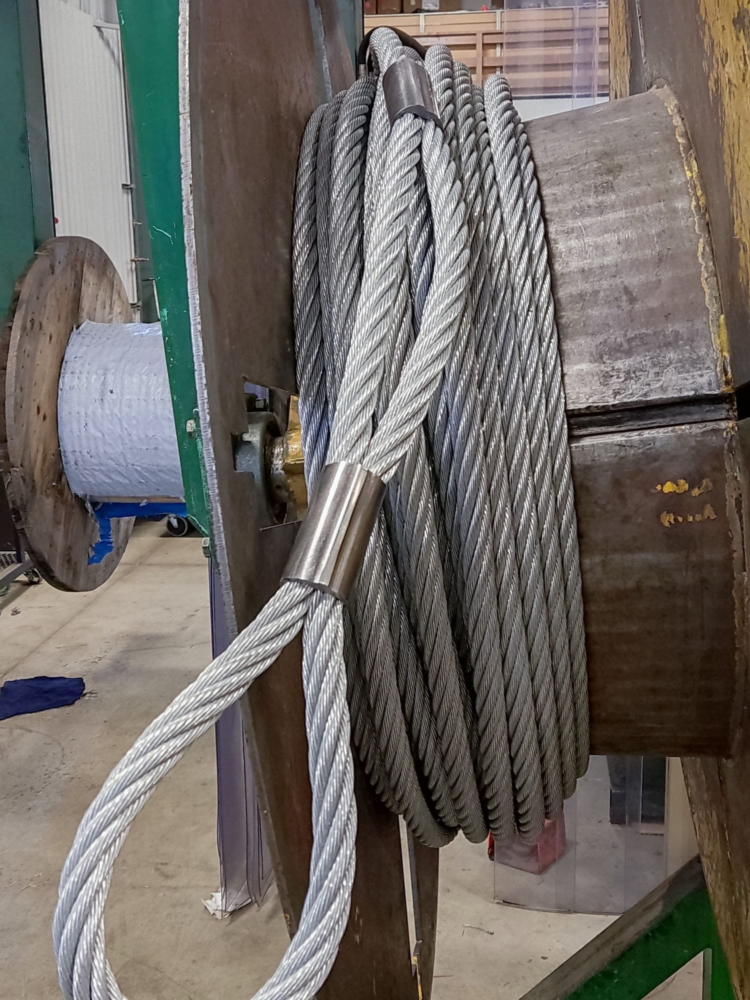 A wire rope assembly with its eye made up, coiled and hung on the drum flange in the shop