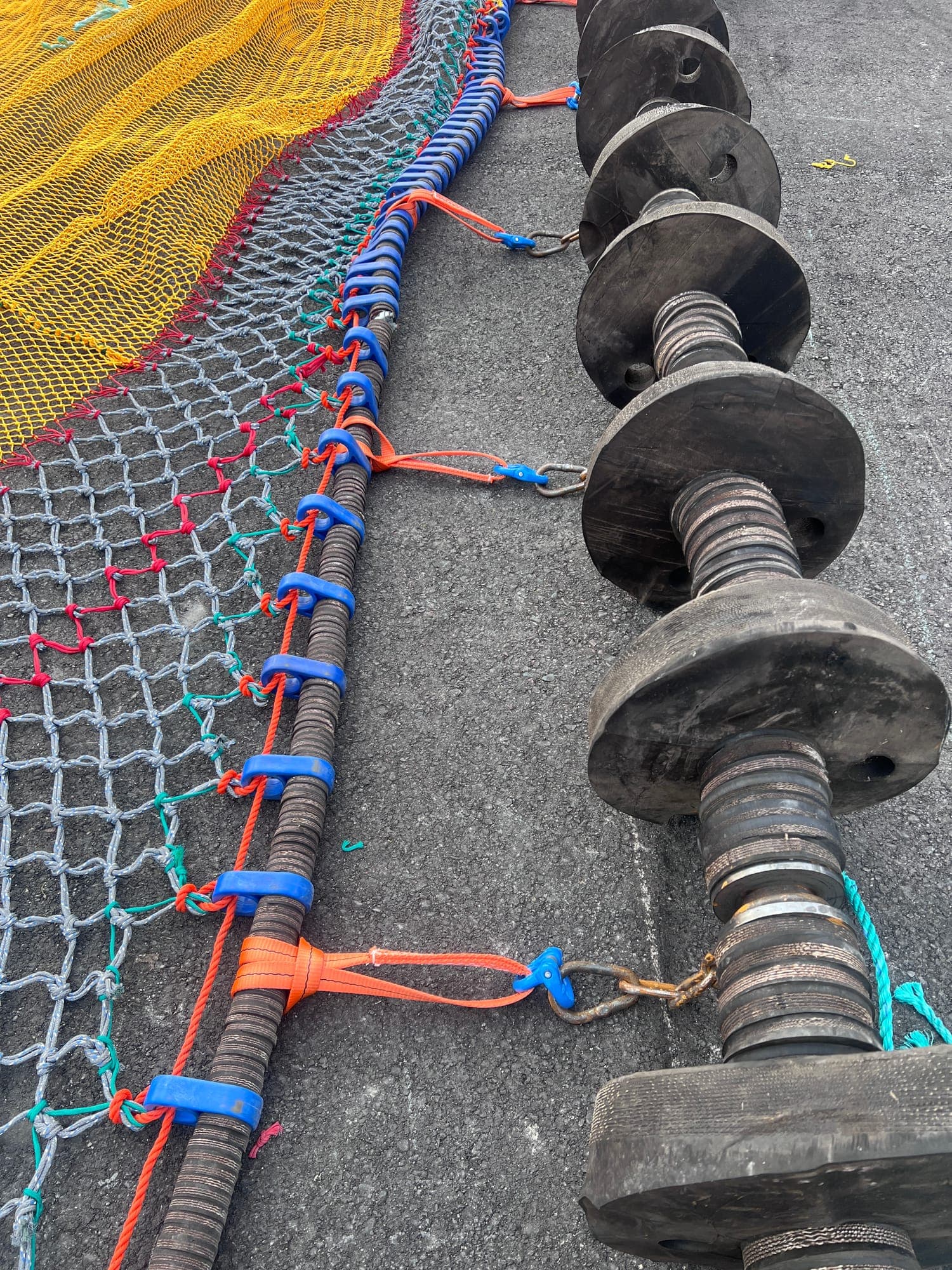 A rockhopper footrope laid out with the netting laced to it, lashings colour-coded