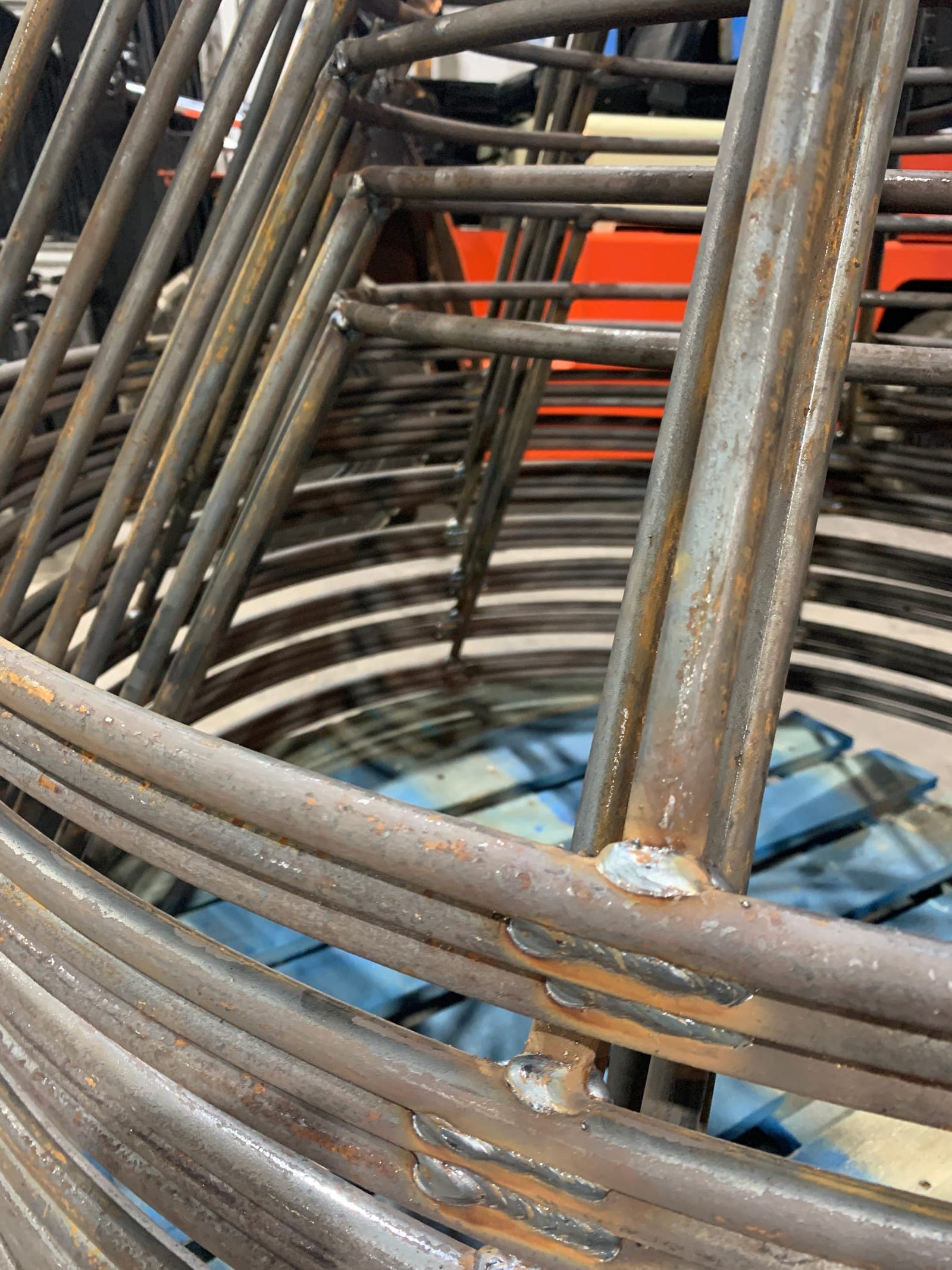Bare steel crab frames stacked in the shop, the rolled bows and welded joints still bright